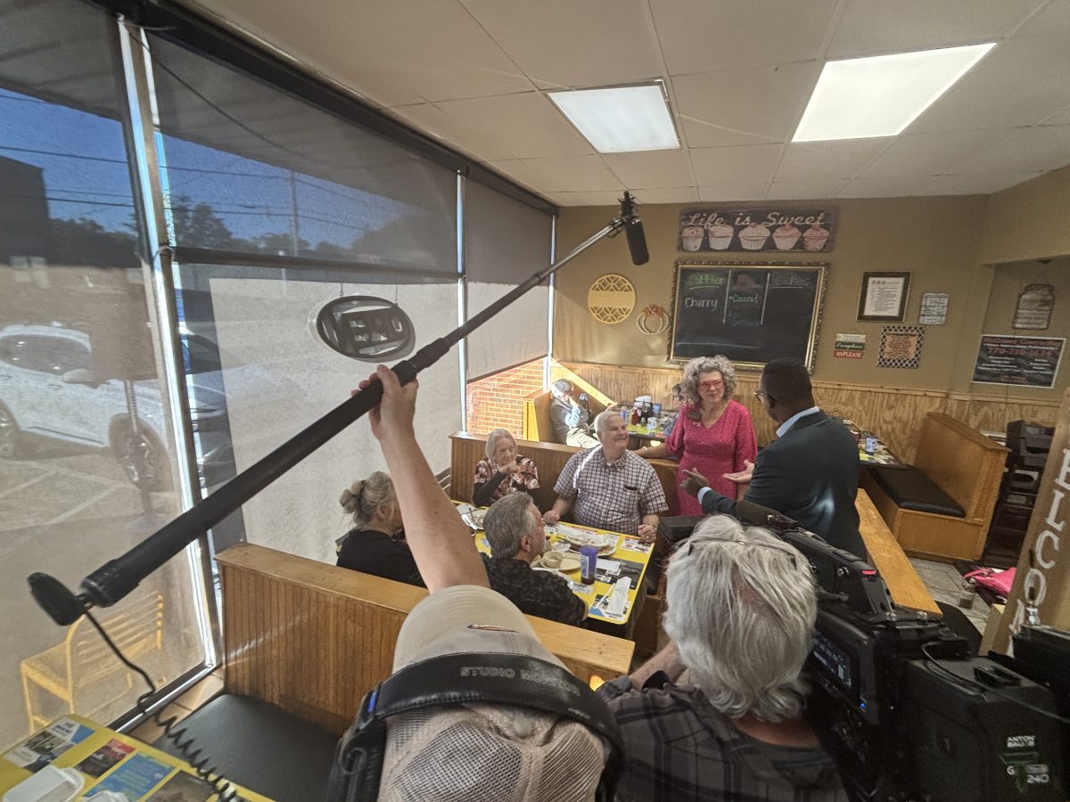 Boom operator holding a microphone over a restaurant interview during an ABC News shoot in Paulding County, Georgia